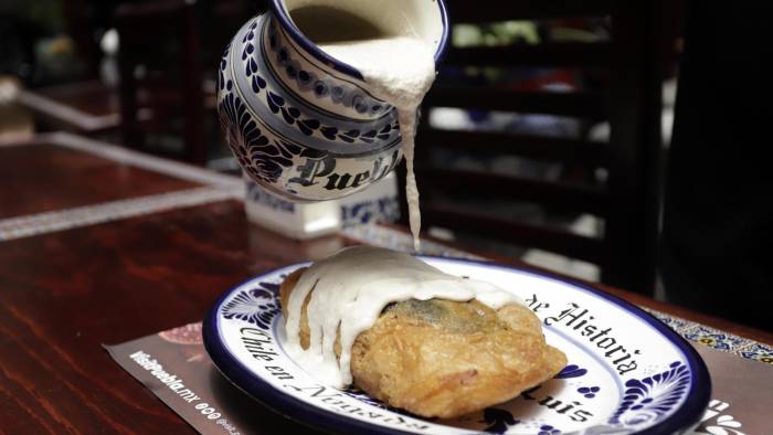 El chile poblano se rellena con carne y frutas tradicionales.