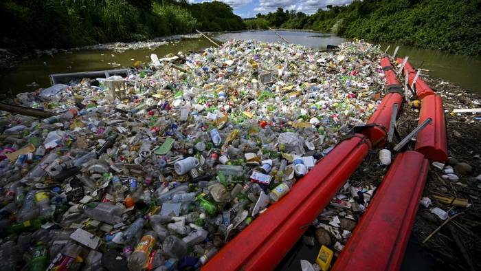 La basura es arrastrada por la corriente del río San Juan hasta una barrera.