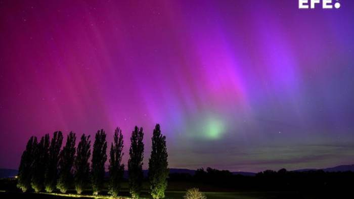 Vista de la aurora boreal vista durante la noche del viernes en Daillens, Suiza.