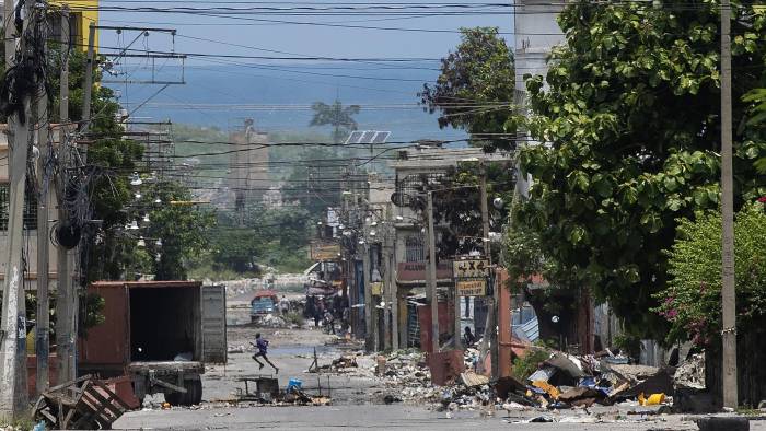 Un hombre cruza corriendo una calle cercana al Palacio Nacional, zona de frecuentes enfrentamientos entre la policía y las bandas armadas, este sábado, en Puerto Príncipe