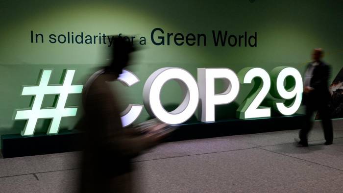 Los asistentes pasan junto al logotipo de la COP29 durante la Conferencia de las Naciones Unidas sobre el cambio climático.