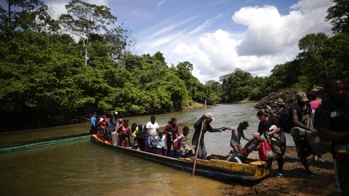 Fotografía de archivo de migrantes mientras descienden de una canoa antes de llegar a la Estación de Recepción Migratoria de Lajas Blancas, luego de atravesar la selva del Darién.