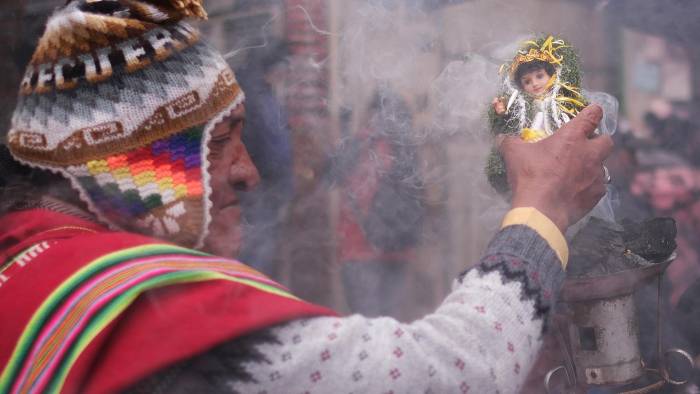 Un sacerdote aimara o 'amauta' sostiene una imagen del niño Jesús durante la misa de Reyes este lunes, en La Paz (Bolivia).