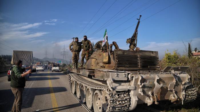 Fuerzas de seguridad sirias se encuentran sobre un tanque mientras participan en una operación tras los ataques realizados en su contra.