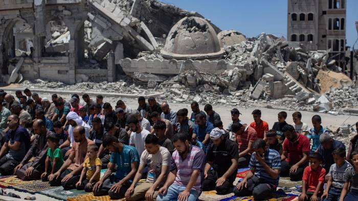 Ciudadanos palestinos desplazados durante la oración del viernes en las ruinas de la Mezquita Al-Islam, previamente destruida en un ataque aéreo israelí en Khan Yunis, al sur de la Franja de Gaza, este viernes.