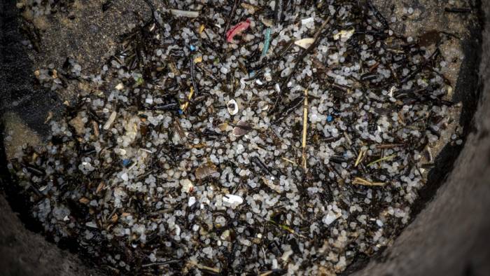 Detalle de los pellets de plástico recogidos por los operarios contratados por Tragsa en la playa de Seiras (Porto do Son), A Coruña, después de que el buque 'Toconao', con bandera de Liberia, perdiera 26.250 kilos de estas diminutas bolitas frente a las costas portuguesas.