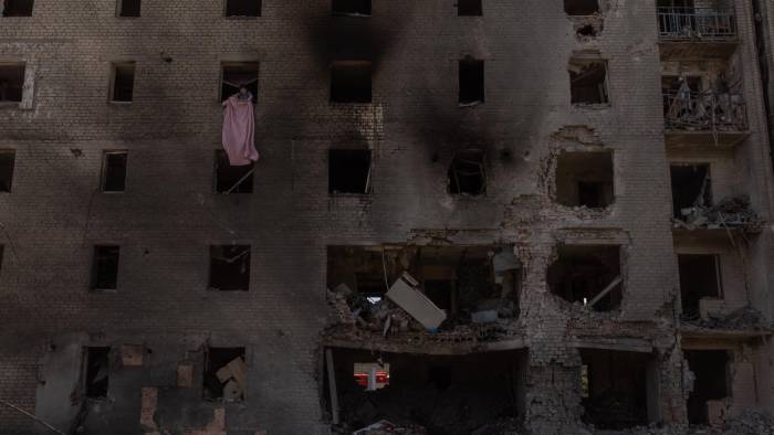 Una mujer limpia los escombros de un apartamento en un edificio residencial muy dañado tras un ataque aéreo ruso, en Selydove, la región oriental de Donetsk, el 27 de junio de 2024,