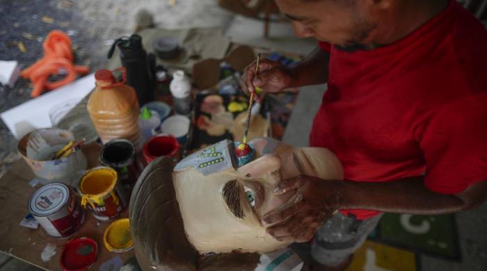 Víctor Álvarez, un artista plástico panameño de 32 años, trabaja en la elaboración de muñecos de año viejo el 26 de diciembre de 2023, en Chame (Panamá).