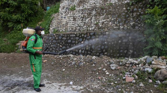 Un integrante de la Comisión Militar y Policial fumiga para eliminar criaderos del mosquito transmisor del dengue en Santo Domingo.
