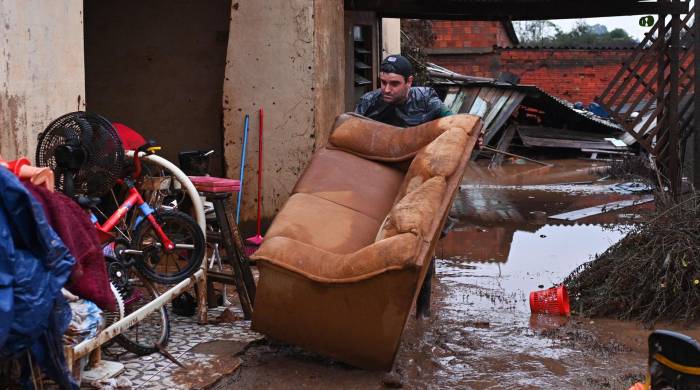 Everton Lemes intenta rescatar un sofá afectados por una inundación este domingo en el municipio de Río Pardo, estado de Rio Grande do Sul (Brasil).