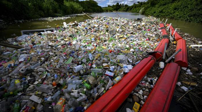 La basura es arrastrada por la corriente del río San Juan hasta una barrera.