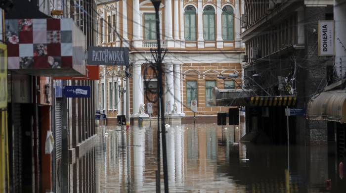 Fotografía que muestra una calle inundación de agua y basura este lunes, en Porto Alegre, Brasil.