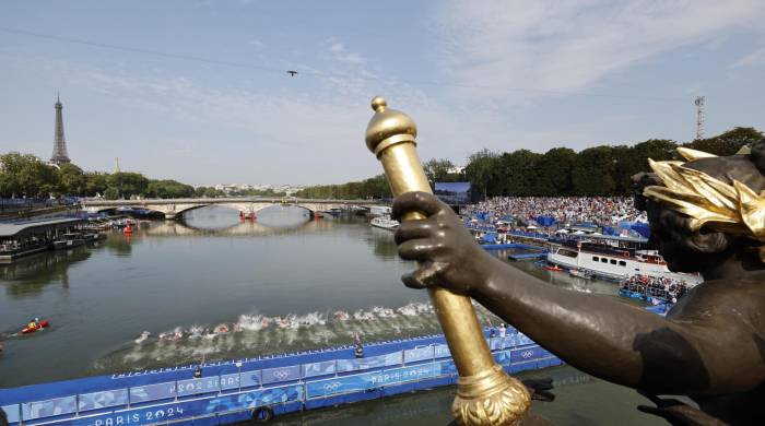 Atletas compiten en el triatlon masculino en el río Sena.