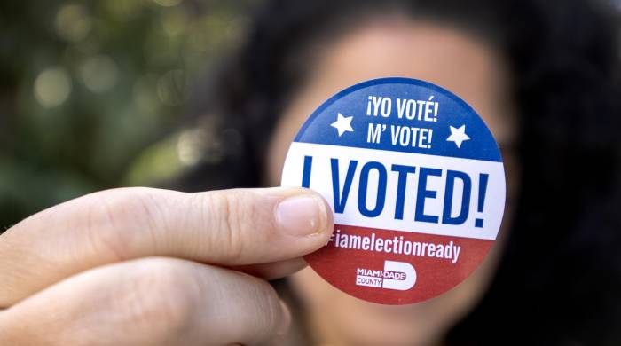 Una persona muestra una calcomanía de Yo voté después de emitir su voto en la biblioteca de Palmetto Bay en la votación anticipada para las elecciones presidenciales estadounidenses de 2024 en Miami.