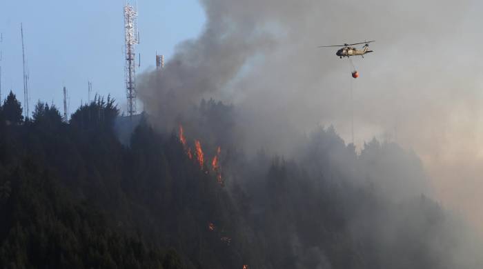 Un helicóptero combate hoy un incendio forestal en el cerro El Cable, en Bogotá (Colombia).