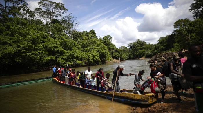 Fotografía de archivo de migrantes mientras descienden de una canoa antes de llegar a la Estación de Recepción Migratoria de Lajas Blancas luego de atravesar la selva del Darién.