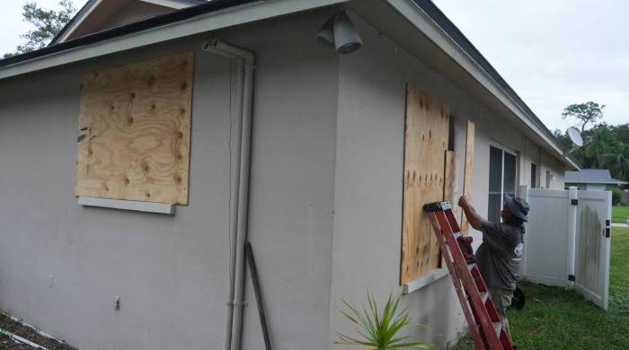 Un residente tapa sus ventanas con tablas en Palm Harbor, Florida, antes de la llegada prevista del huracán Milton a mitad de semana el 6 de octubre.