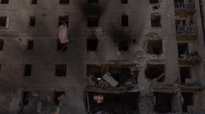 Una mujer limpia los escombros de un apartamento en un edificio residencial muy dañado tras un ataque aéreo ruso, en Selydove, la región oriental de Donetsk, el 27 de junio de 2024,