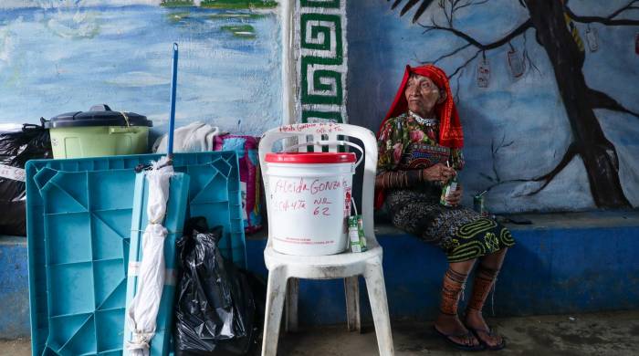 Mujer guna de la isla Gardí Sugdub esperando ser trasladada a tierra firme para llegar a su nueva hogar: la barrida Nuevo Cartí.