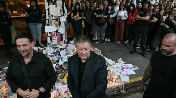 Geoff Payne (centro), el padre del cantante pop de One Direction, Liam Payne, camina frente al lugar donde los fanáticos rindieron homenaje a su difunto hijo fuera del hotel CasaSur en Buenos Aires, el 18 de octubre de 2024.