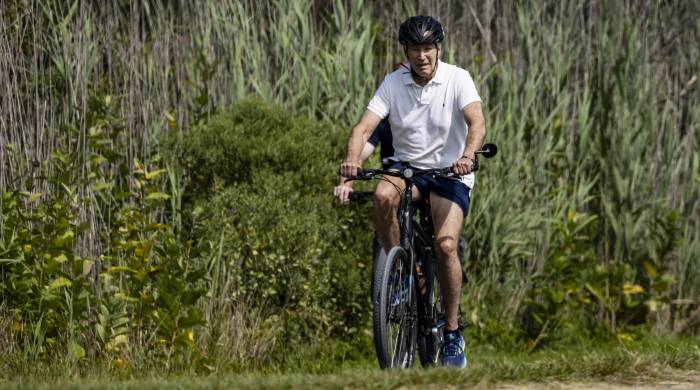 El presidente estadounidense Joe Biden pasea en bicicleta por el parque estatal Gordons Pond en Rehoboth Beach, Delaware, el 11 de agosto de 2024.