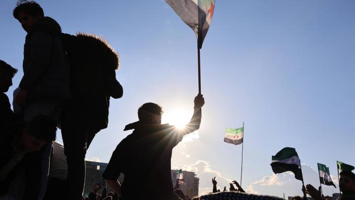 La gente se reúne para celebrar la toma de control de la oposición en Damasco, tras las oraciones del viernes, en la Plaza de los Omeyas en Damasco, Siria.