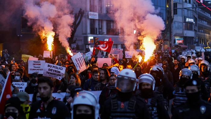 Escoltados por la policía antidisturbios, estudiantes encienden bengalas mientras caminan desde el distrito de Beşiktaş de Estambul hasta el distrito de Sarachane y el Ayuntamiento de la Municipalidad Metropolitana.