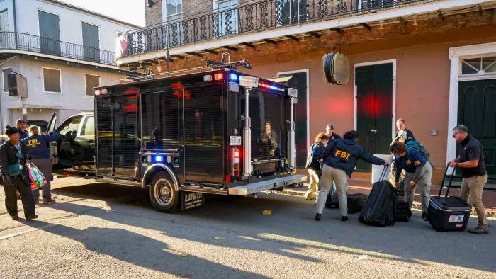 Investigadores del FBI llegan al lugar donde la camioneta blanca Ford F-150 se estrelló contra un elevador de trabajo, después de atropellar a una multitud en Año Nuevo.