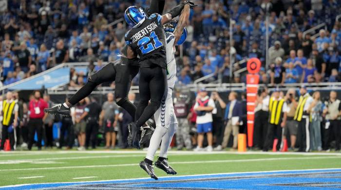 Kerby Joseph, de los Detroit Lions y Jaxon Smith-Njigba, de los Seattle Seahawks durante un partido entre ambos equipos.