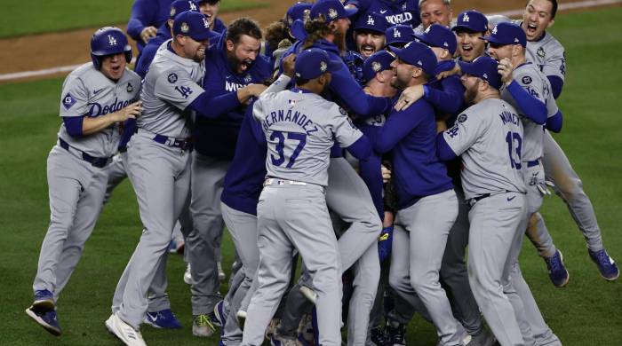 El pitcher de los Los Angeles Dodgers, Walker Buehler (C), es rodeado por sus compañeros de equipo para celebrar tras el último out contra los New York Yankees.