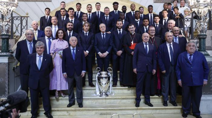 Los jugadores y cuerpo técnico del Real Madrid posan para la foto de familia junto al arzobispo de Madrid, José Cobo (cd), en la Catedral de la Almudena, primera parada del recorrido realizado este domingo por el equipo para celebrar su victoria en la final de la Liga de Campeones.
