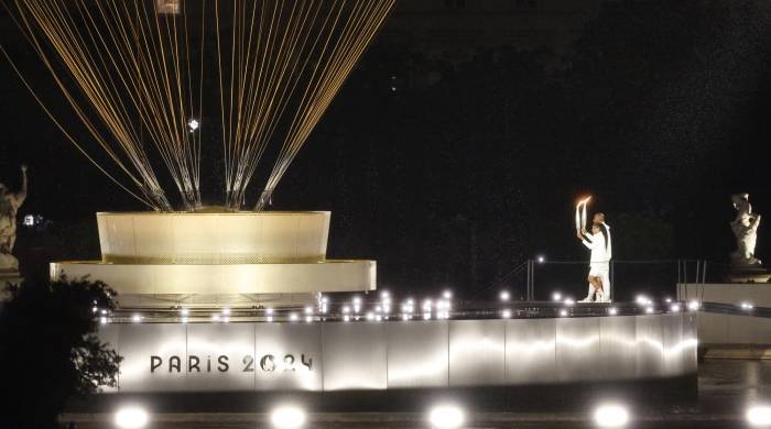 Los atletas galos Marie-Jose Perec (i) y Teddy Riner (d) se dirigen con la antorcha olímpica al pebetero durante la ceremonia de inauguración de los Juegos Olímpicos de París 2024.