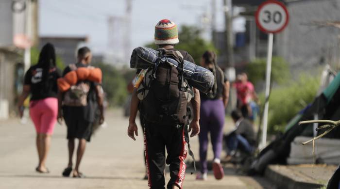 Migrantes caminan por una calle en la subregión de Urabá, en el municipio de Turbo.