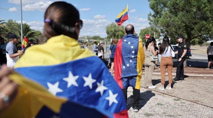 Venezolanos sostienen banderas durante la llegada de Edmundo González Urrutia al aeropuerto militar de Torrejón de Ardoz en Madrid