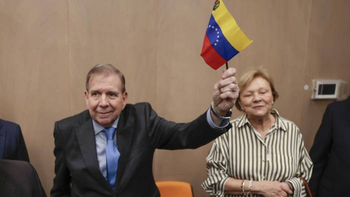 El líder opositor venezolano Edmundo González Urrutia sostiene una bandera de Venezuela a su llegada a un encuentro con ciudadanos venezolanos residentes en Guatemala este 15 de enero.