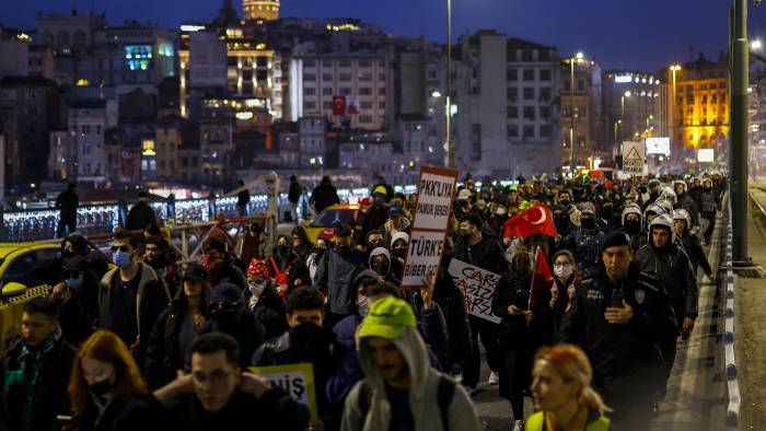 Escoltados por la policía antidisturbios, la gente cruza el puente de Gálata.