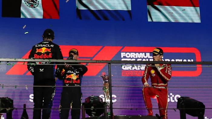 (I-D) El piloto de Red Bull Racing, el mexicano Sergio Perez, junto al ganador del GP el neerlandés Max Verstappeny el tercero en la carrera, el piloto de Ferrari Charles Leclerc, monegasco, celebran el podio en Yeda.