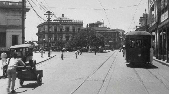 Avenida Central de la ciudad de Panamá cerca de la estación del Ferrocarril, Panamá 1924. Véase los distintos modos de transporte (peatones, tranvías, vehículos a motor y carruajes tirados por caballos) apostados sobre la estación de ferrocarril.