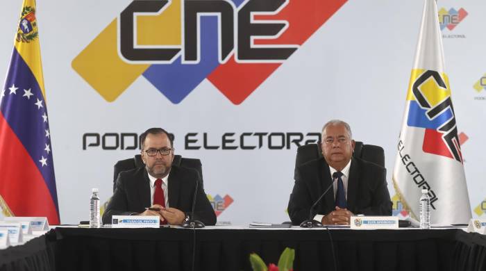 El canciller de venezuela, Yvan Gil (i), asiste a una reunión con el presidente del consejo nacional electoral, Elvis Amoroso (d), este jueves en Caracas.