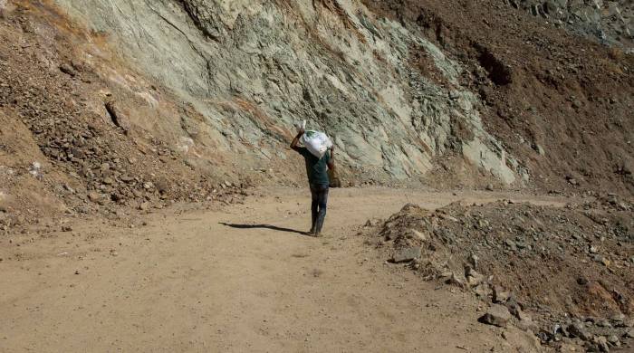 Fotografía de archivo en donde se ve a un joven cargando un saco de tierra con oro en una mina de Nicaragua.