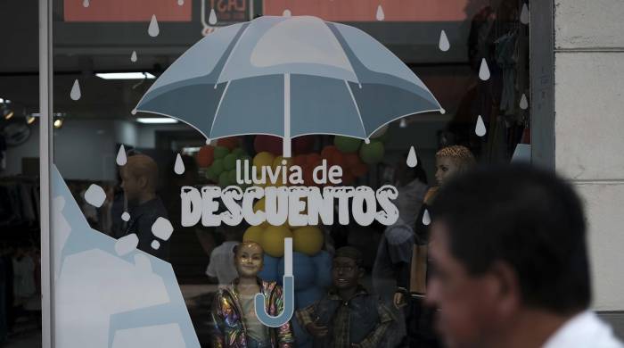 Un hombre camina junto a un local comercial en San José (Costa Rica.