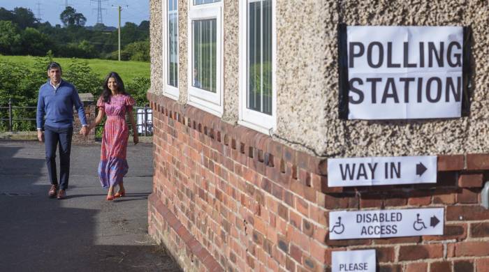 El primer ministro británico Rishi Sunak y su esposa Akshata Murty a su llegada al colegio electoral durante las elecciones generales británicas.