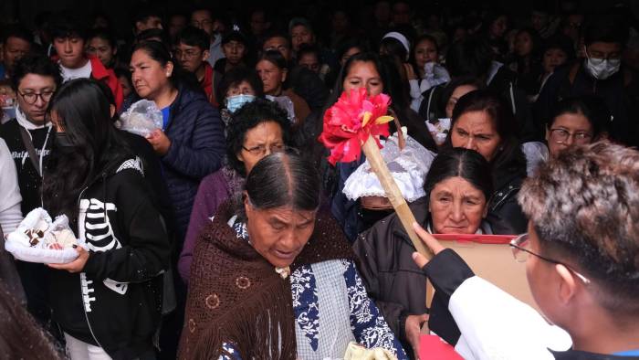 Fieles católicos reciben agua bendita durante la misa de Reyes este lunes, en La Paz (Bolivia).