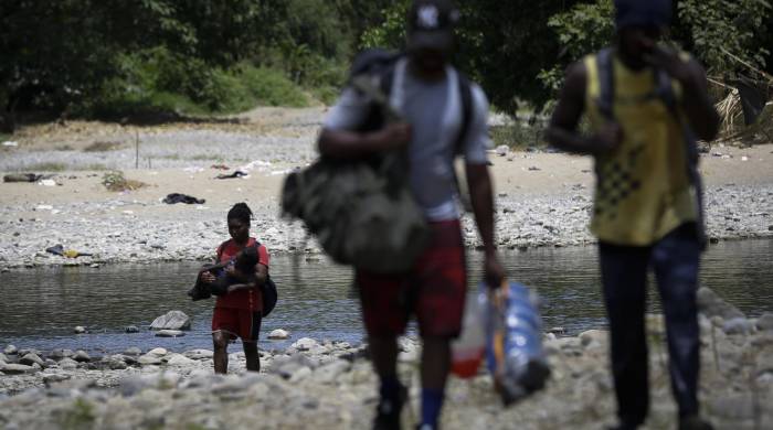 Personas migrantes cruzan el río Tuquesa en Darién (Panamá), en una fotografía de archivos. EFE/ Bienvenido Velasco