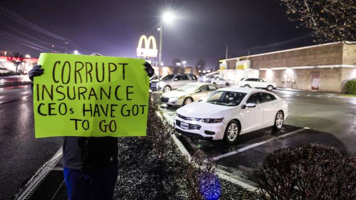 Una mujer, que no quiso ser identificada y que trabaja en la industria de la salud, sostiene un cartel de protesta frente al restaurante McDonald's donde el Departamento de Policía de Altoona arrestó a Luigi Mangione.