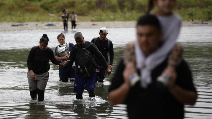 Foto de archivo de migrantes cruzando el río Tuquesa luego de atravesar la selva del Darién, en Panamá.