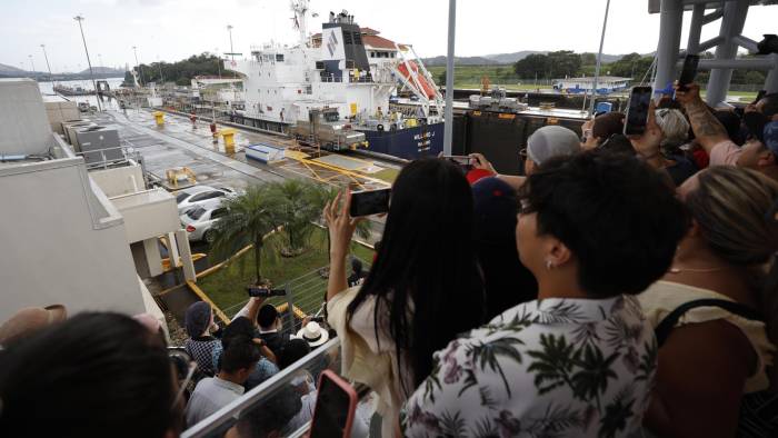 Personas observan el paso de un barco por una sección de las esclusas Miraflores del Canal de Panamá.