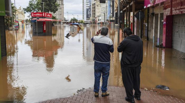 PORTO ALEGRE (BRASIL), 05/05/2024.- Dos hombres observan una zona inundada este domingo, tras la crecida del lago Guaíba en la ciudad de Porto Alegre (Brasil). Las devastadoras inundaciones en el sur de Brasil han provocado la muerte de al menos 67 personas, mientras que otras 101 permanecen desaparecidas, informaron las autoridades en la mañana de este domingo.