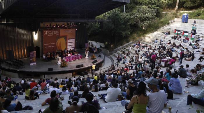 Personas asisten a la inauguración del 34° Festival Internacional de Poesía, este sábado, en el teatro al aire libre Carlos Vieco.