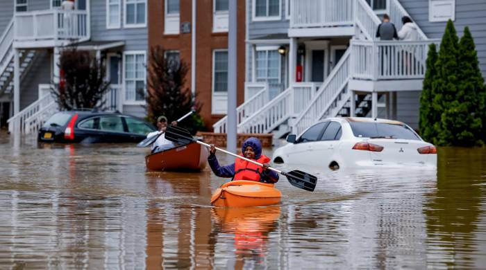 Candice Ocvil (derecha), residente de Peachtree Park Apartments, y Jibri Tolen (izquierda), reman en las aguas de la inundación de Peachtree Creek después de que Helene atravesara Atlanta, Georgia, EE. UU., el 27 de septiembre de 2024.